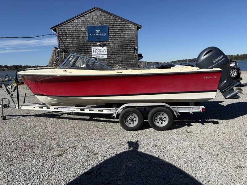 Slide: The Image of A red 2020 Rossiter 20 boat on a trailer, parked near a waterfront building. - 9