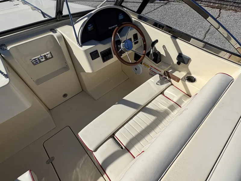 Slide: The Image of The image shows the cockpit of a 2020 Rossiter 20 boat with cream seats and a wooden steering wheel. - 25