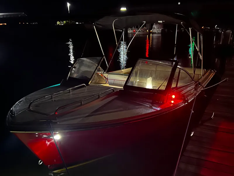 Slide: The Image of A 2020 Rossiter 20 boat docked at night, illuminated by colorful lights. - 4