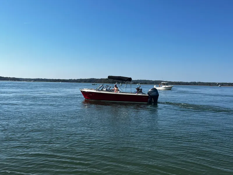 Slide: The Image of A red motorboat with a sunshade cruises on calm water. - 5