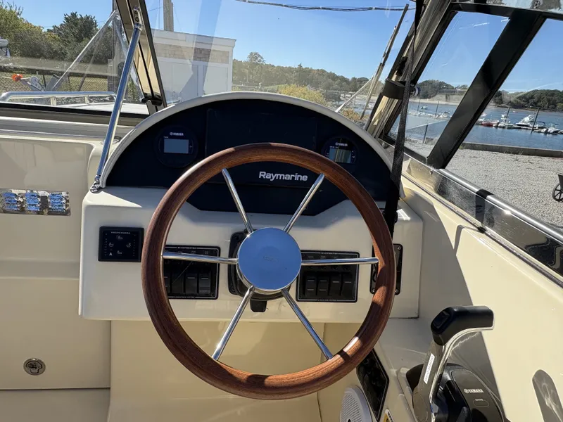 Slide: The Image of The image shows the cockpit of a 2020 Rossiter 20 boat with a wooden steering wheel. - 27