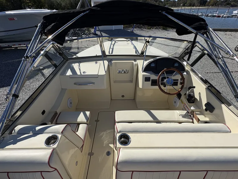 Slide: The Image of The image shows the cockpit of a 2020 Rossiter 20 boat with cream seats and a black canopy. - 20