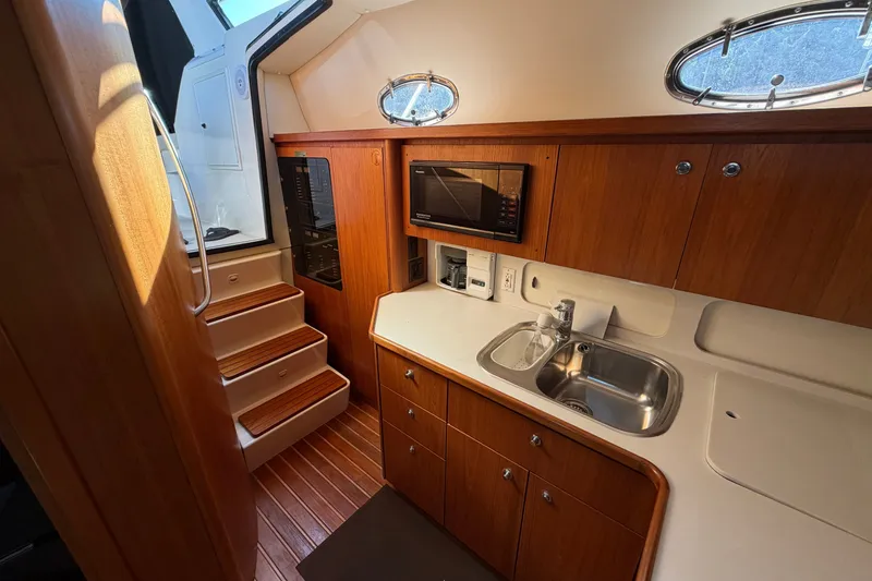 Slide: The Image of 1998 Tiara Yachts 4000 Express interior kitchen with wooden cabinets and stainless steel sink. - 14