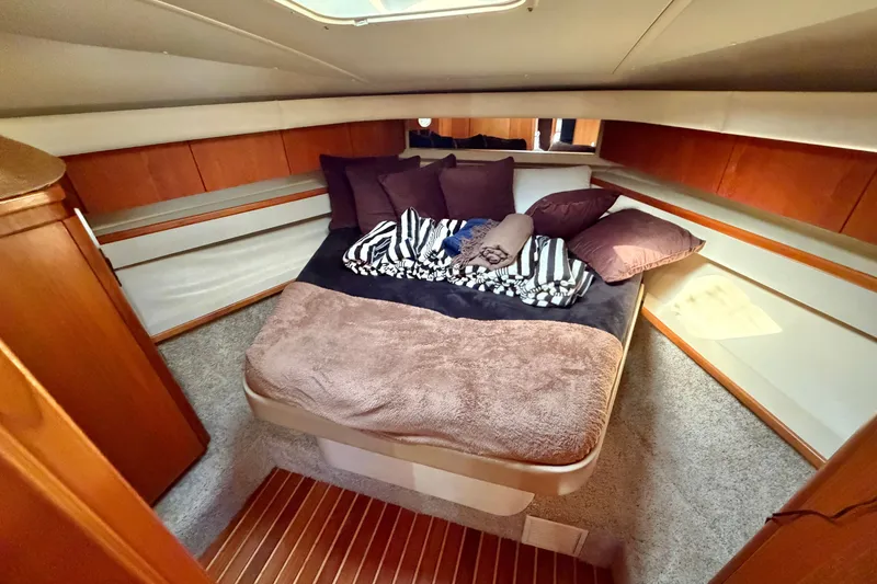 Slide: The Image of Cozy cabin interior of 1998 Tiara Yachts 4000 Express with plush bedding and wood accents. - 22