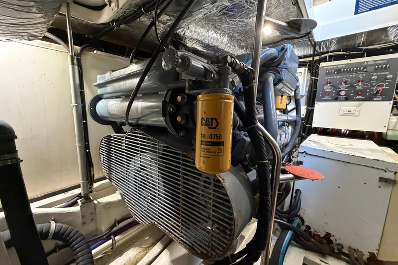 Slide: The Image of Engine room of a 1998 Tiara Yachts 4000 Express, featuring a CAT filter and control panel. - 28