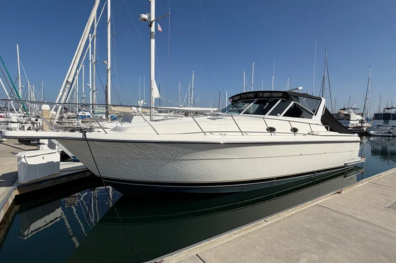 The Image of 1998 Tiara Yachts 4000 Express docked at marina under clear blue sky. - 0