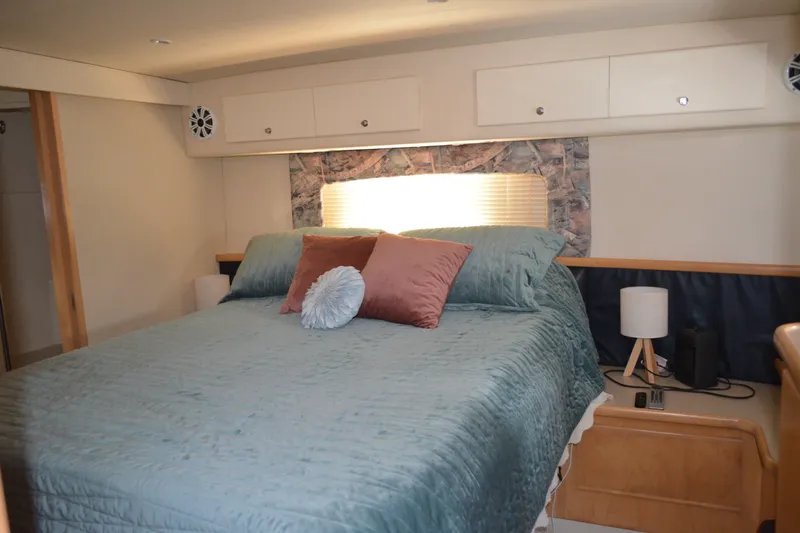 Slide: The Image of Cozy bedroom in 1996 Carver 440 Aft Cabin Motor Yacht with elegant bedding and soft lighting. - 56