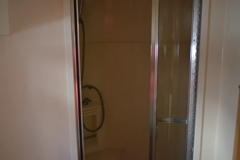 Slide: The Image of Shower area inside 1996 Carver 440 Aft Cabin Motor Yacht, featuring glass door and fixtures. - 64