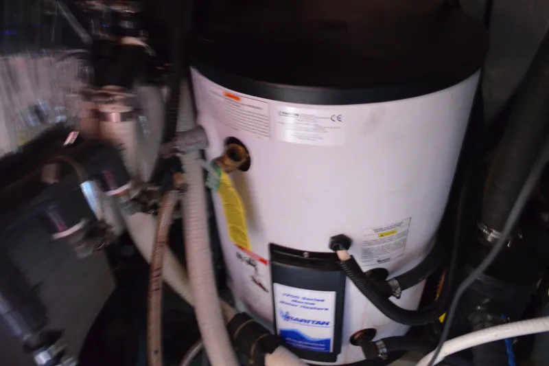 Slide: The Image of Engine room of 1996 Carver 440 Aft Cabin Motor Yacht with water heater and hoses. - 69