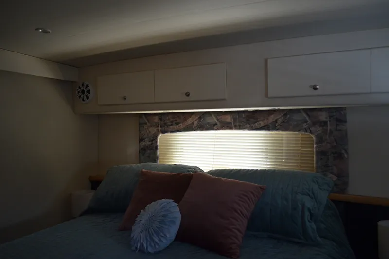 Slide: The Image of Cozy bedroom interior of 1996 Carver 440 Aft Cabin Motor Yacht with pillows and window blinds. - 57