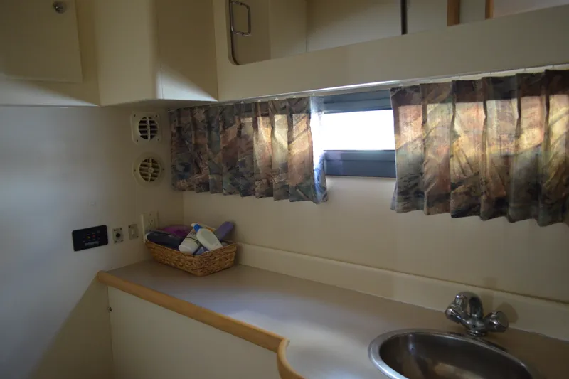 Slide: The Image of Interior of 1996 Carver 440 Aft Cabin Motor Yacht with sink and window curtains. - 62