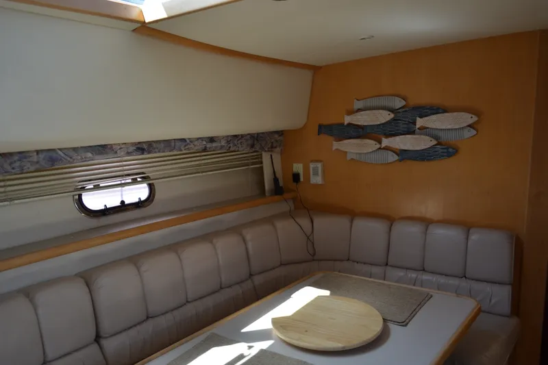 Slide: The Image of Interior of 1996 Carver 440 Aft Cabin Motor Yacht with cozy seating and fish wall art. - 45