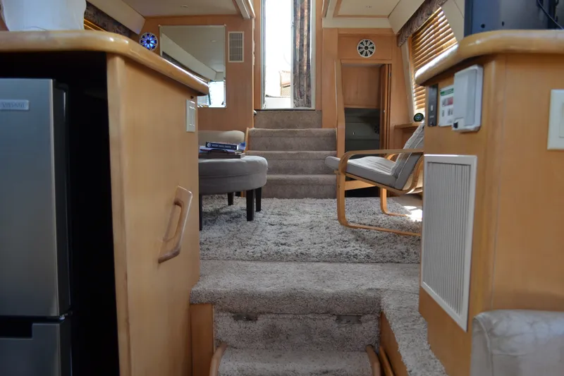 Slide: The Image of Interior of 1996 Carver 440 Aft Cabin Motor Yacht, featuring cozy seating and carpeted stairs. - 38
