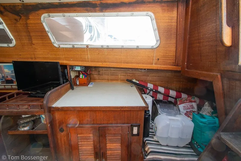 Slide: The Image of Interior of a 1973 Challenger 32 sailboat with wooden cabinetry and nautical equipment. - 20