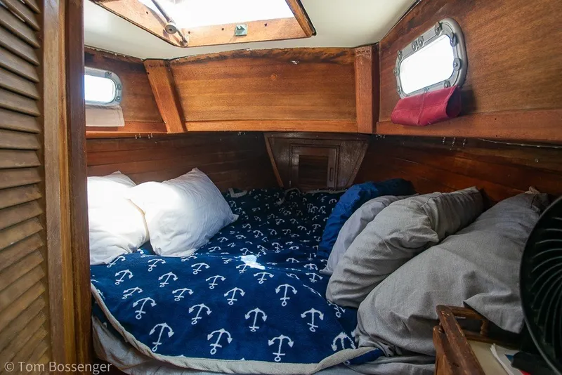 Slide: The Image of Cozy cabin interior of a 1973 Challenger 32 sailboat with nautical-themed bedding. - 18