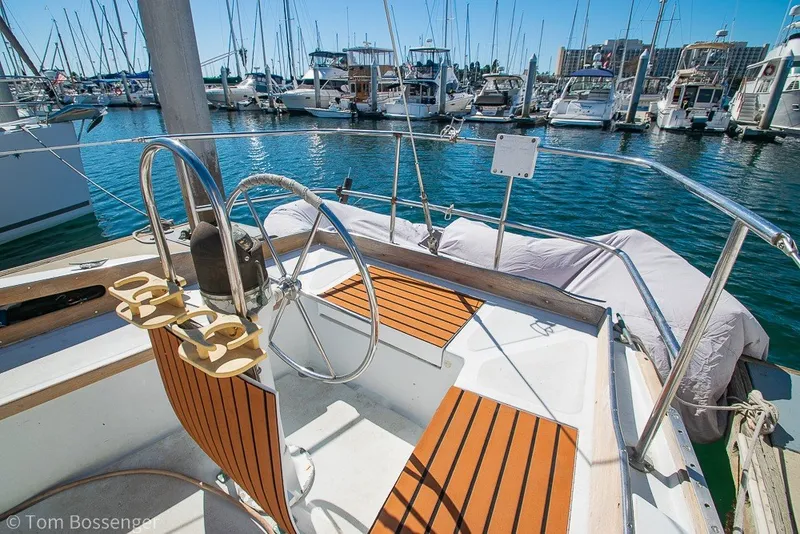Slide: The Image of 1973 Challenger 32 sailboat cockpit with wooden seats, docked in a marina. - 26