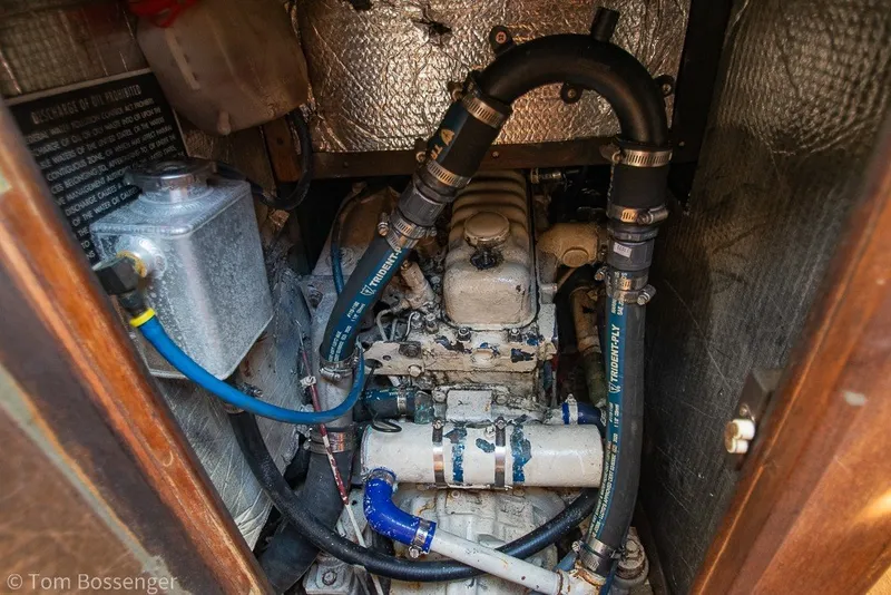 Slide: The Image of Engine compartment of a 1973 Challenger 32 boat, featuring hoses and metal components. - 24