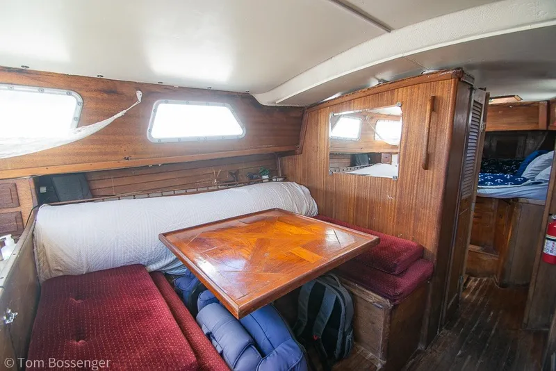 Slide: The Image of Interior of a 1973 Challenger 32 sailboat with wooden furnishings and cozy seating area. - 14