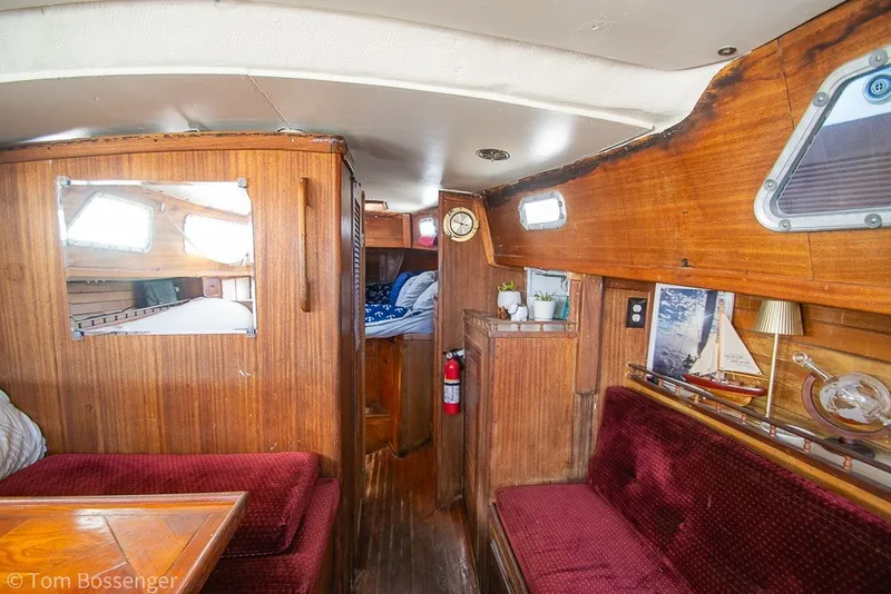 Slide: The Image of Interior of a 1973 Challenger 32 sailboat with wooden paneling and red seating. - 16
