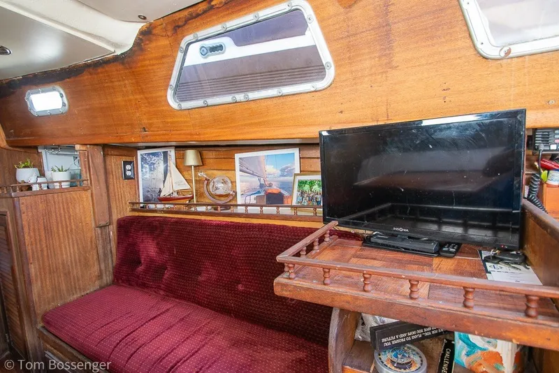 Slide: The Image of 1973 Challenger 32 yacht interior with red seating, TV, and nautical decor. - 15