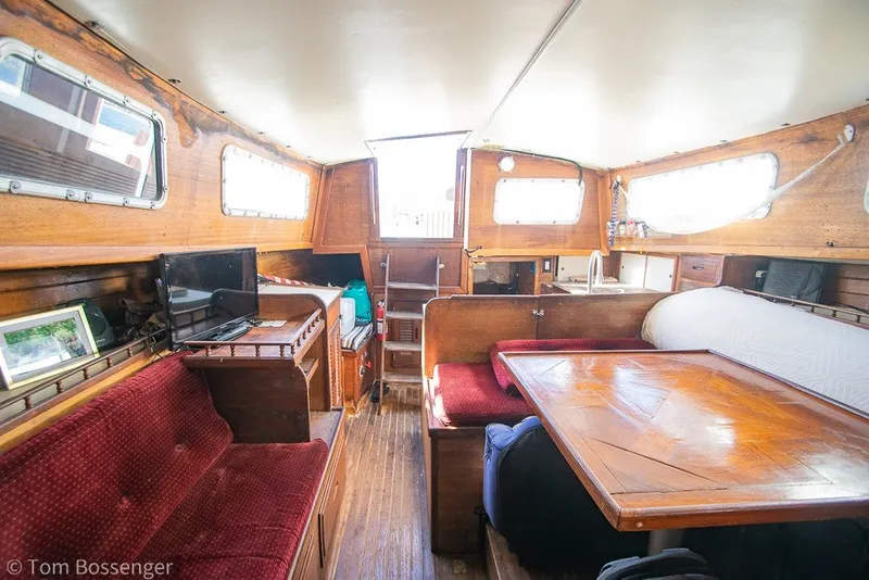 Slide: The Image of Interior of a 1973 Challenger 32 sailboat with wooden furnishings and cozy seating. - 17