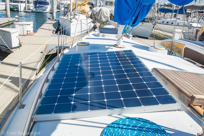 Slide: The Image of 1973 Challenger 32 sailboat with solar panel on deck, docked at marina. - 28