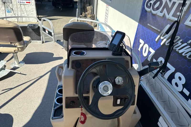 Slide: The Image of 2019 Sun Tracker Bass Buggy 18 DLX pontoon boat cockpit with steering wheel and controls. - 18