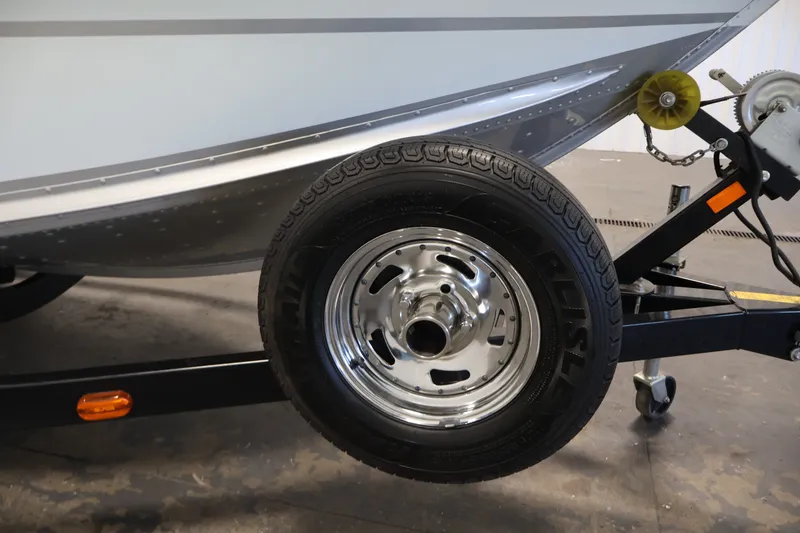 Slide: The Image of Trailer wheel of a 2015 Alumacraft Classic 165 Tiller boat, close-up view. - 32