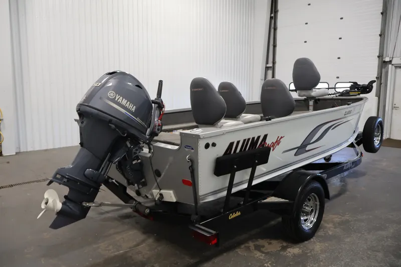 Slide: The Image of 2015 Alumacraft Classic 165 Tiller boat with Yamaha outboard motor in a garage. - 5