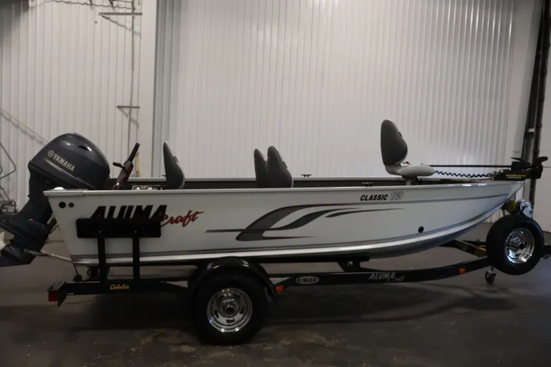 Slide: The Image of 2015 Alumacraft Classic 165 Tiller boat with Yamaha motor on trailer in garage. - 4