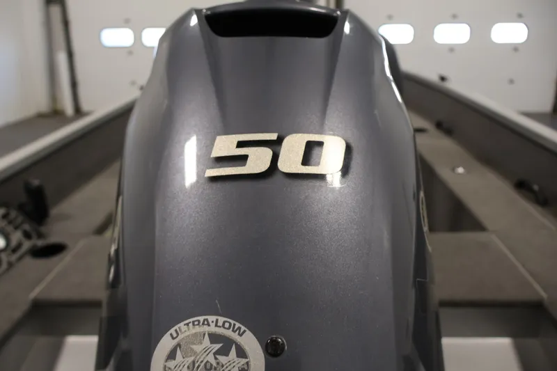 Slide: The Image of 2015 Alumacraft Classic 165 Tiller boat with 150 HP engine in a garage setting. - 29