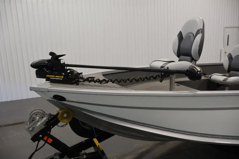 Slide: The Image of 2015 Alumacraft Classic 165 Tiller boat with Minn Kota trolling motor in a garage. - 11