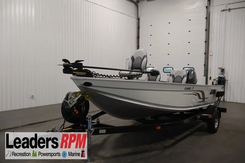 Slide: The Image of 2015 Alumacraft Classic 165 Tiller boat on trailer in indoor showroom. - 1