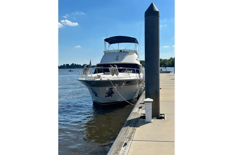 Slide: The Image of 1988 Silverton 37 Convertible yacht docked at a marina on a sunny day. - 2