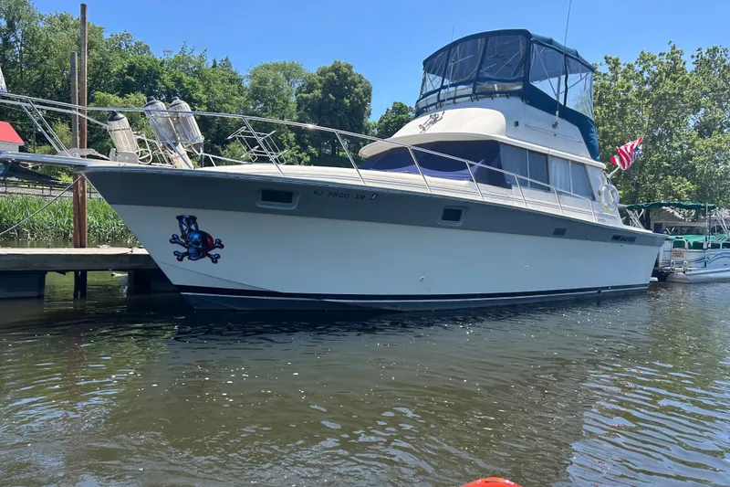 Slide: The Image of 1988 Silverton 37 Convertible yacht docked on a sunny day, featuring a pirate-themed decal. - 4