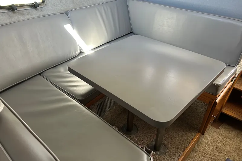 Slide: The Image of 1988 Silverton 37 Convertible interior with gray cushioned seating and table. - 12