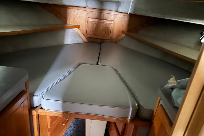 Slide: The Image of 1988 Silverton 37 Convertible cabin interior with cushioned V-berth and wooden cabinetry. - 13