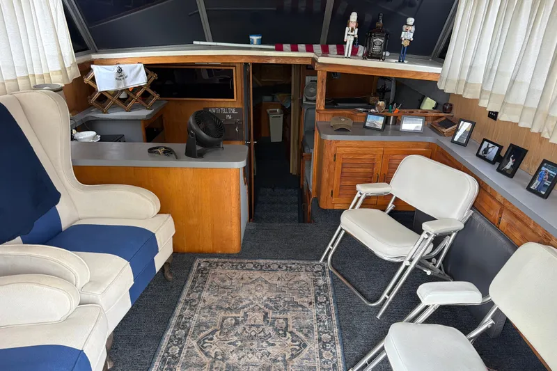 Slide: The Image of Interior of a 1988 Silverton 37 Convertible yacht with cozy seating and nautical decor. - 9