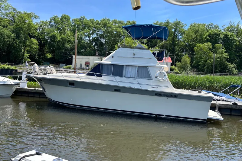 Slide: The Image of 1988 Silverton 37 Convertible yacht docked in a serene marina setting. - 3