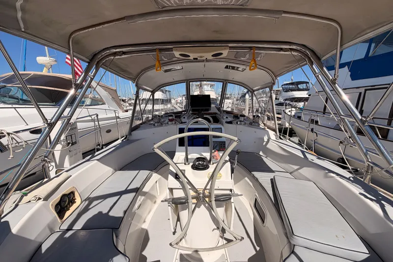 Slide: The Image of Interior view of a 2002 Hunter 460 sailboat cockpit, featuring seating and navigation equipment. - 28