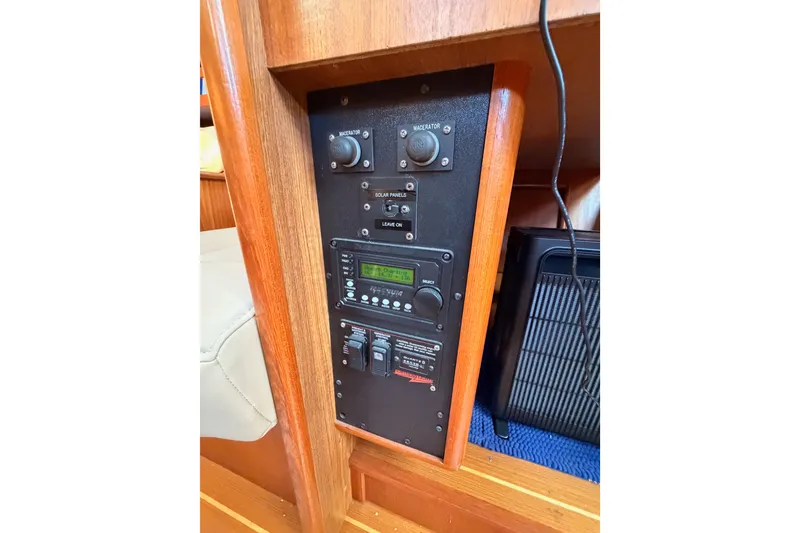 Slide: The Image of Control panel of a 2002 Hunter 460 yacht, featuring switches and display. - 58