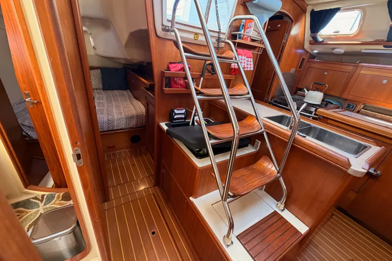 Slide: The Image of Interior of a 2002 Hunter 460 sailboat featuring a cozy cabin and kitchen area. - 54