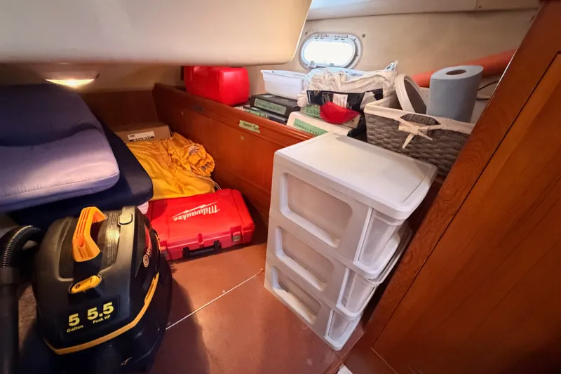 Slide: The Image of Interior storage area of a 2002 Hunter 460 boat with various items and equipment. - 46