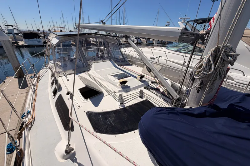 Slide: The Image of 2002 Hunter 460 sailboat docked at marina, showcasing deck and rigging details. - 16