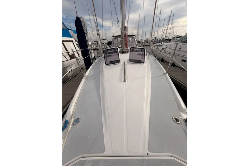 Slide: The Image of 2002 Hunter 460 sailboat deck view, docked in a marina under a cloudy sky. - 15