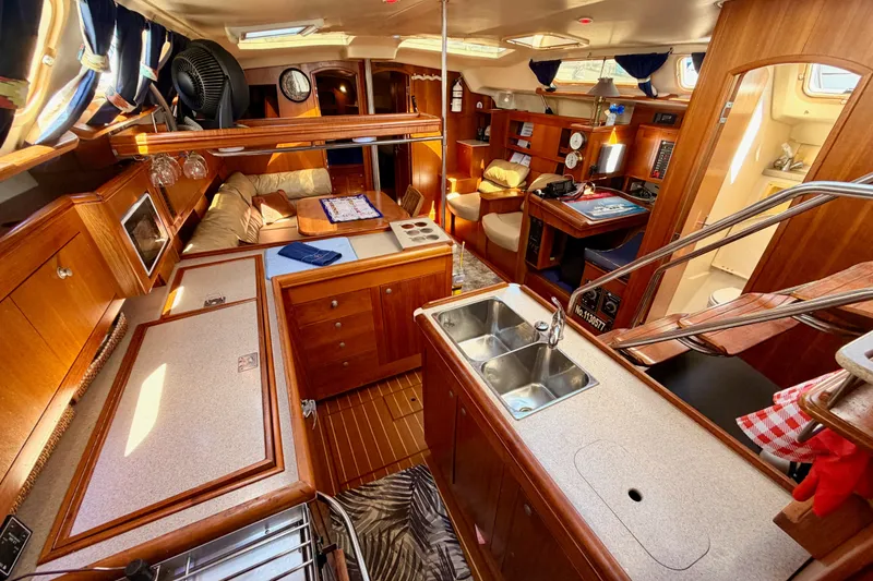 Slide: The Image of Luxurious 2002 Hunter 460 yacht interior with wood finish, kitchen, and seating area. - 49