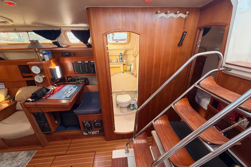 Slide: The Image of Interior of a 2002 Hunter 460 sailboat featuring a cozy cabin and wooden staircase. - 50