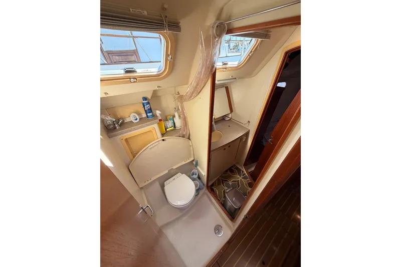Slide: The Image of Bathroom interior of a 2002 Hunter 460 yacht, featuring a compact design and wooden accents. - 51