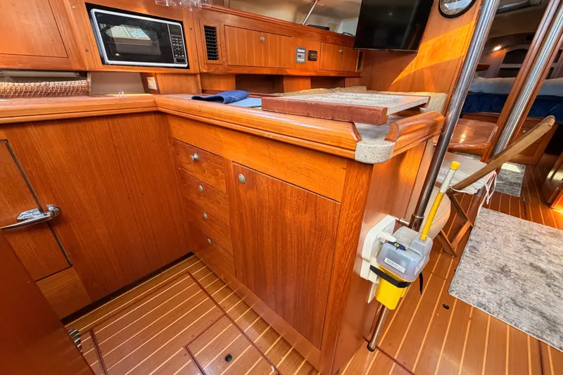 Slide: The Image of Interior of 2002 Hunter 460 yacht featuring wooden cabinetry and modern amenities. - 39