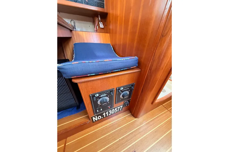 Slide: The Image of Interior of a 2002 Hunter 460 yacht, featuring wooden paneling and control panel. - 59